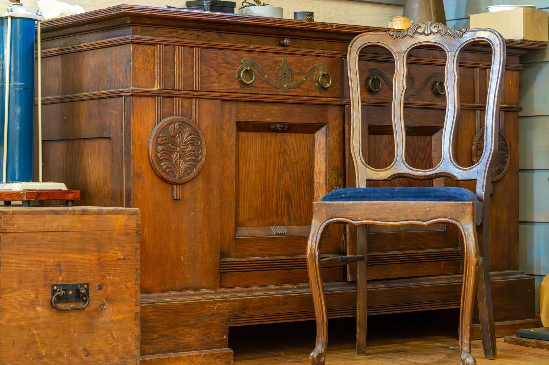Luxurious vintage wooden sideboard with elegant wooden chair featuring blue upholstered seat