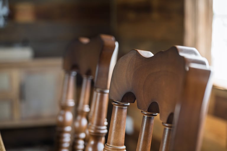 Vintage wooden chairs with intricate carved backrests in a rustic interior