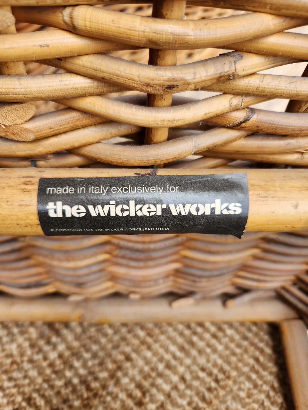 Close-up of wicker chair frame with a label reading made in Italy exclusively for the wicker works