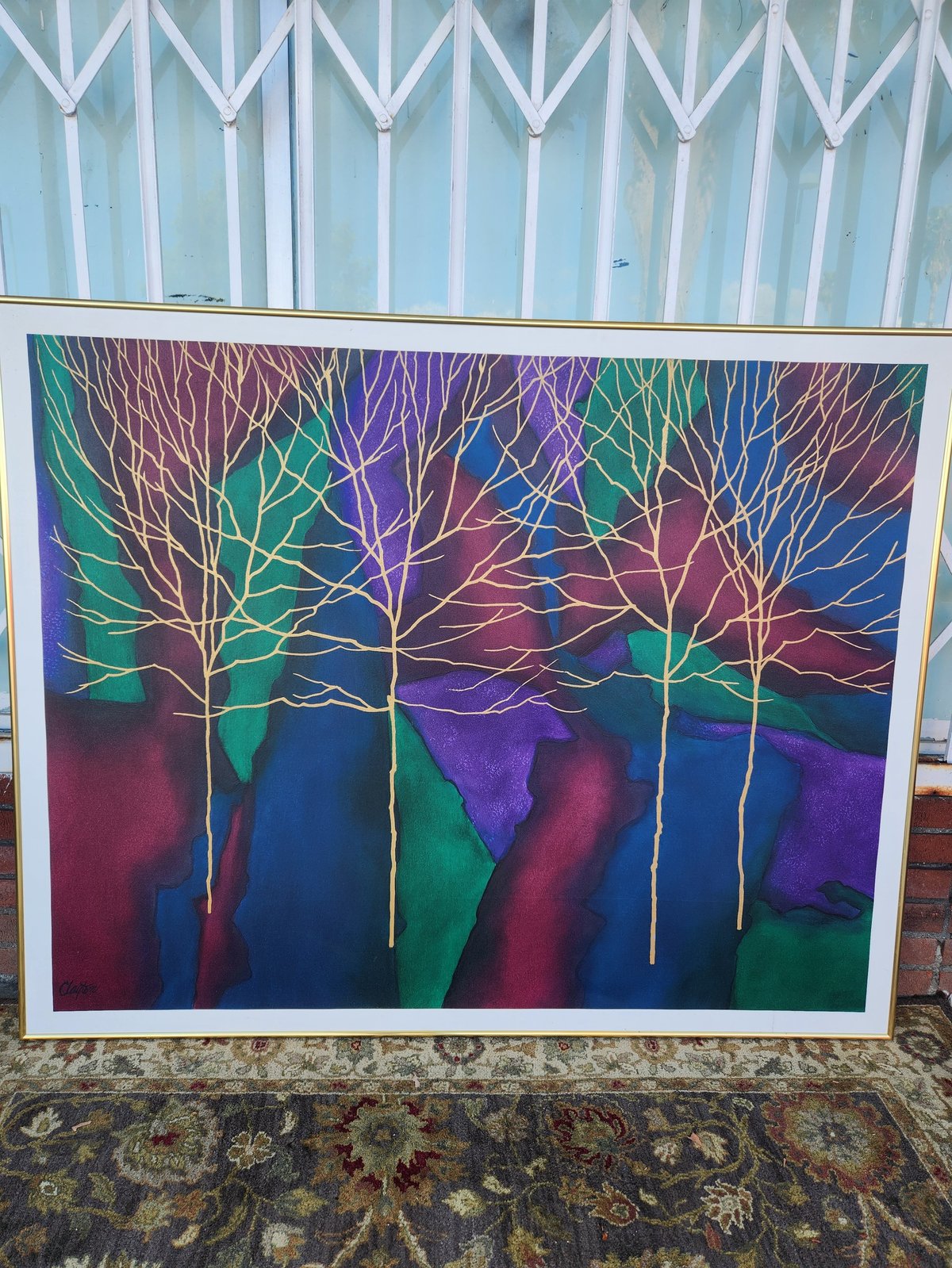 Colorful abstract painting of bare trees with intertwined branches against a vibrant blue, purple, green, and red gradient background