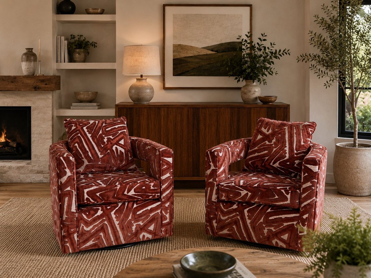 Two burgundy patterned armchairs facing each other in a modern living room with fireplace, wooden cabinet, and framed artwork.