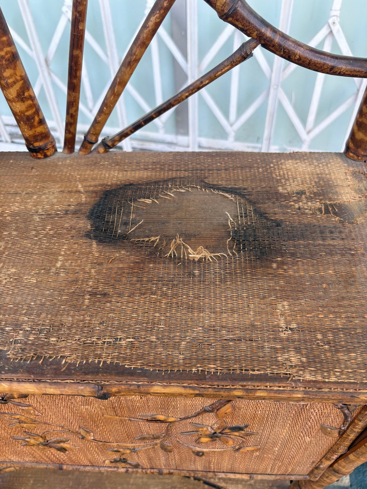 Carved wooden furniture with etched fish design and curved branch details, displayed indoors near a window