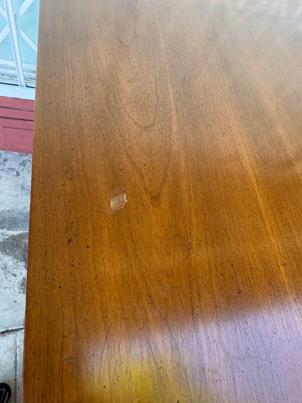 Close-up of wooden floor with brown stain and minor wear marks visible on the surface