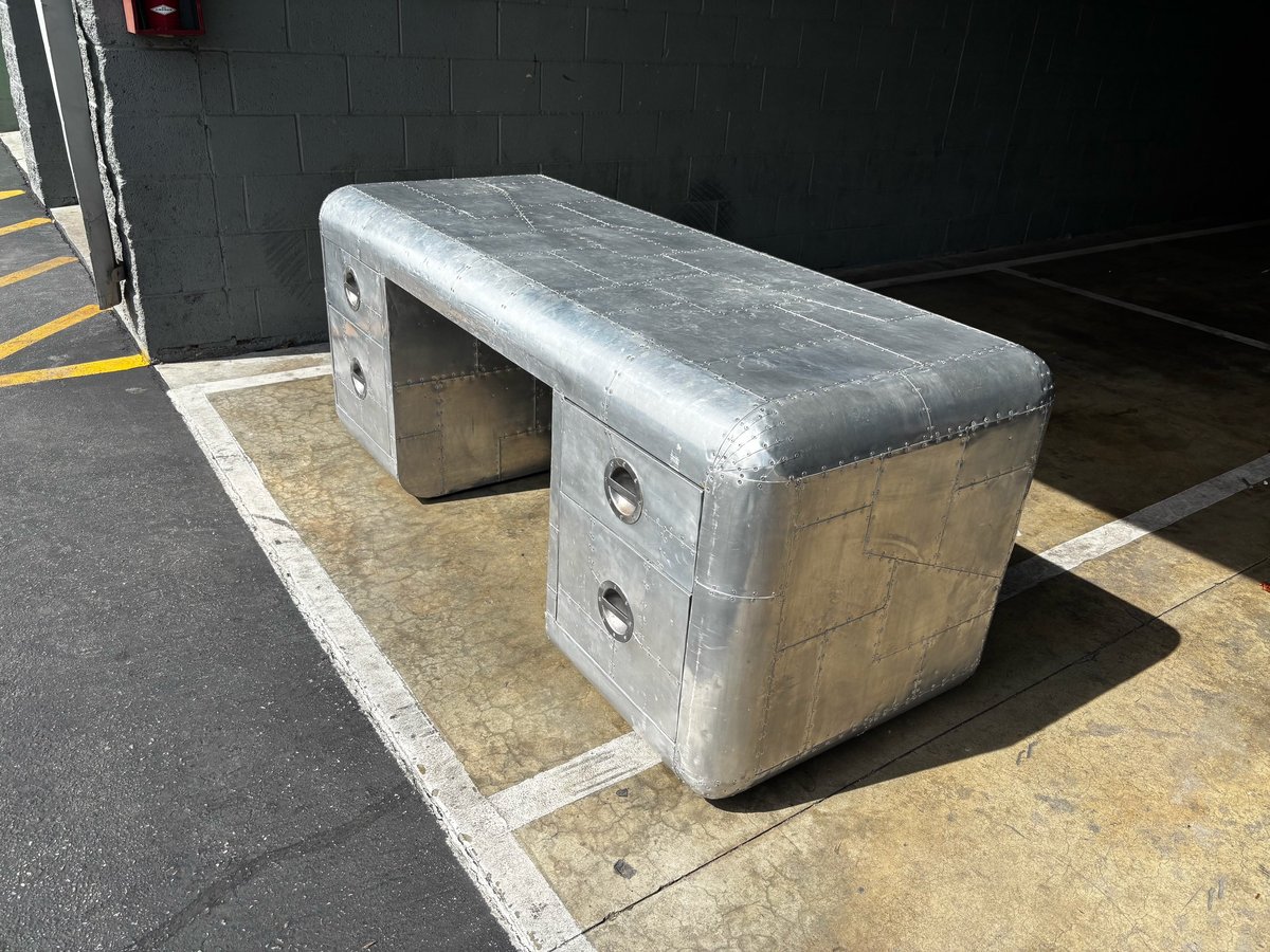 Metal storage bench with drawers positioned on a marked floor space in an industrial garage setting