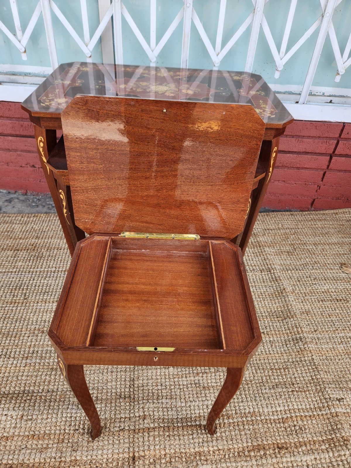Open wooden antique side table with glass top, showing interior storage compartment and curved legs
