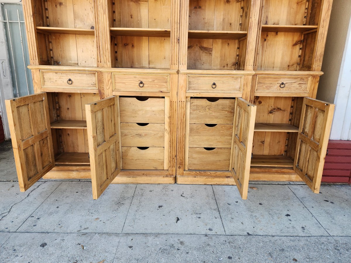 Large wooden storage cabinet with glass doors, open cabinets, and multiple drawers displayed outdoors on concrete