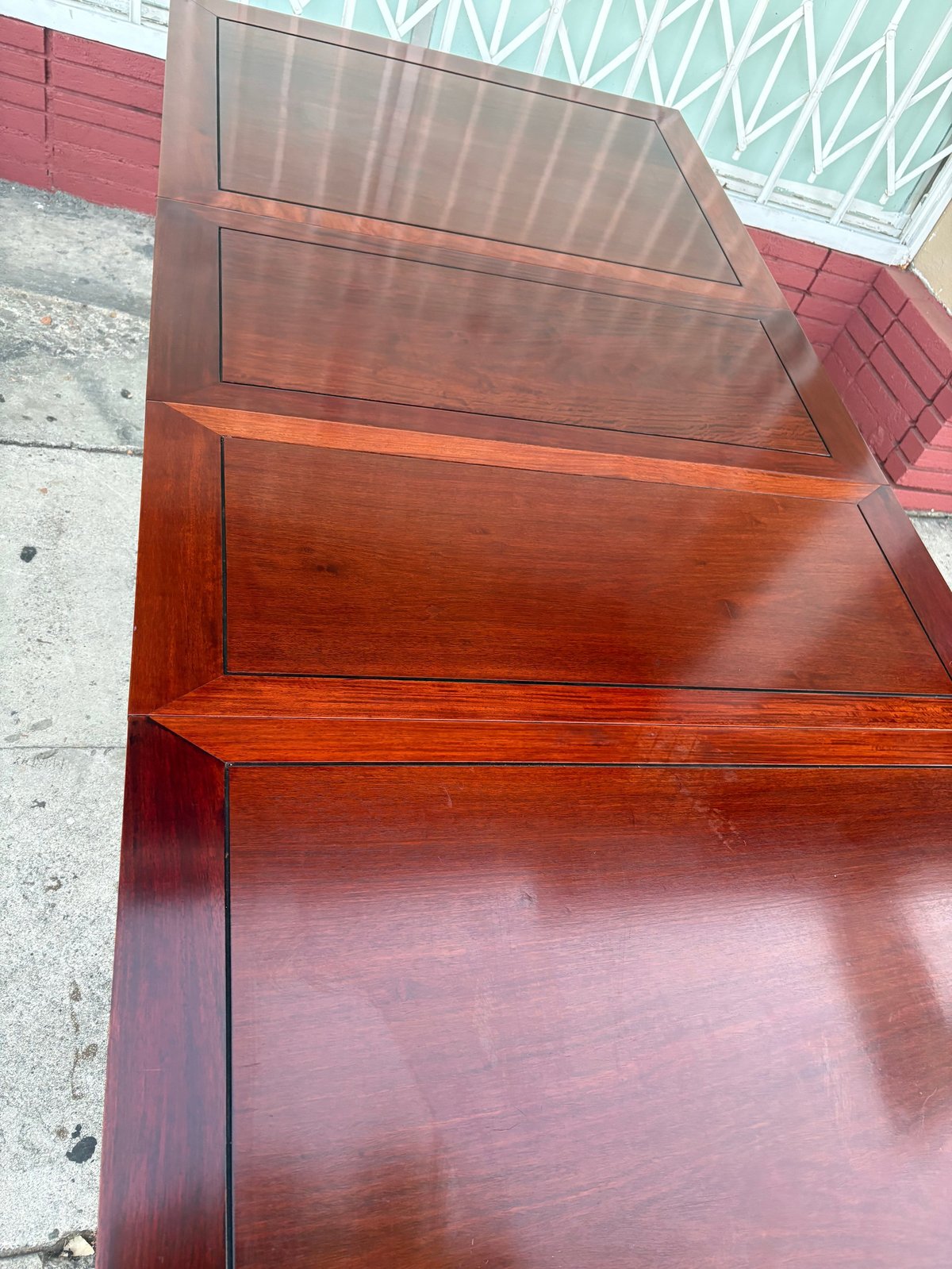 Stacked wooden tables with cherry or mahogany finish showing graduated sizes and reflective surfaces, photographed from above