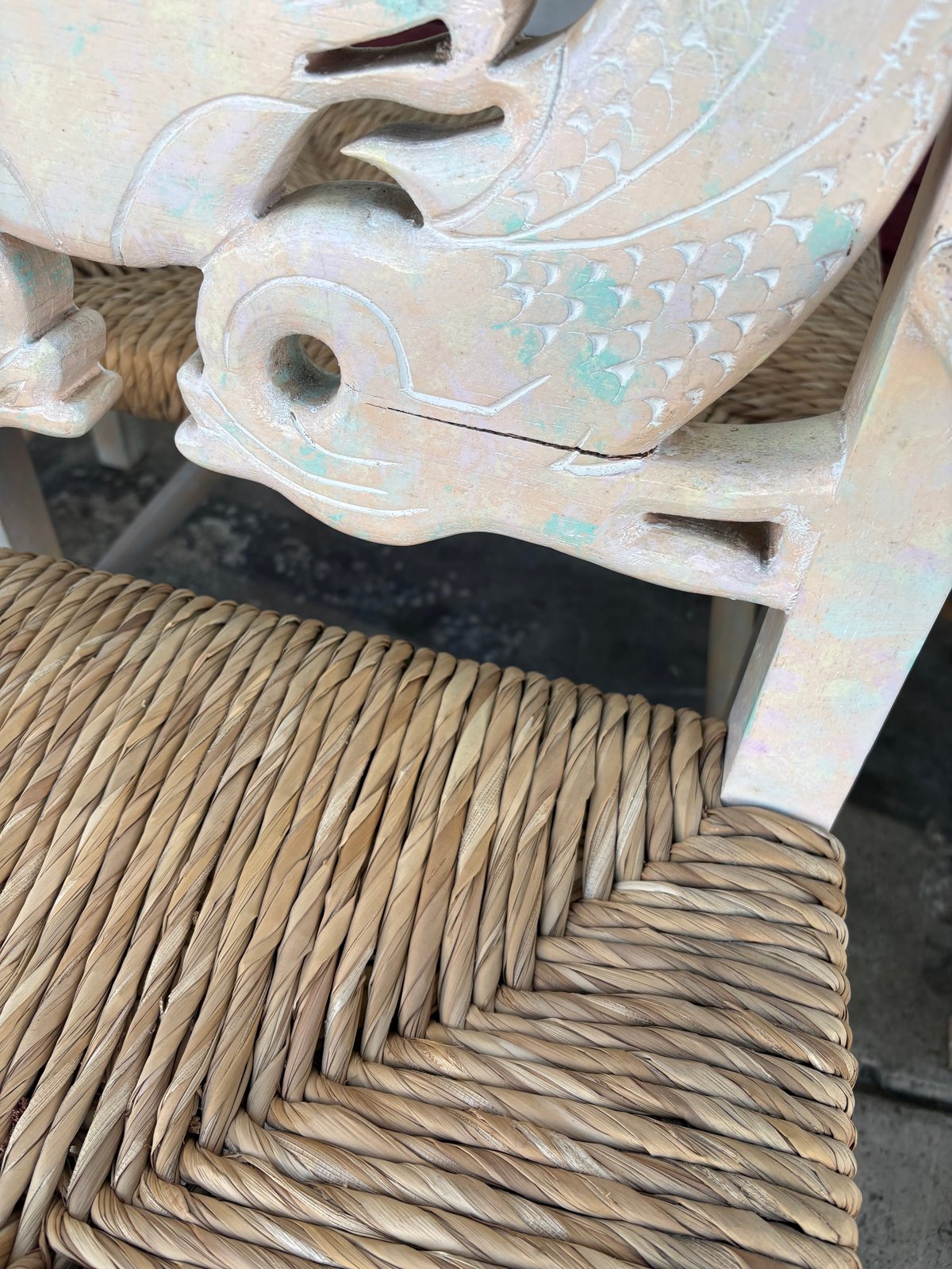 Decorative woven chair seat with iridescent carved backrest detail, showing herringbone weave pattern in natural materials