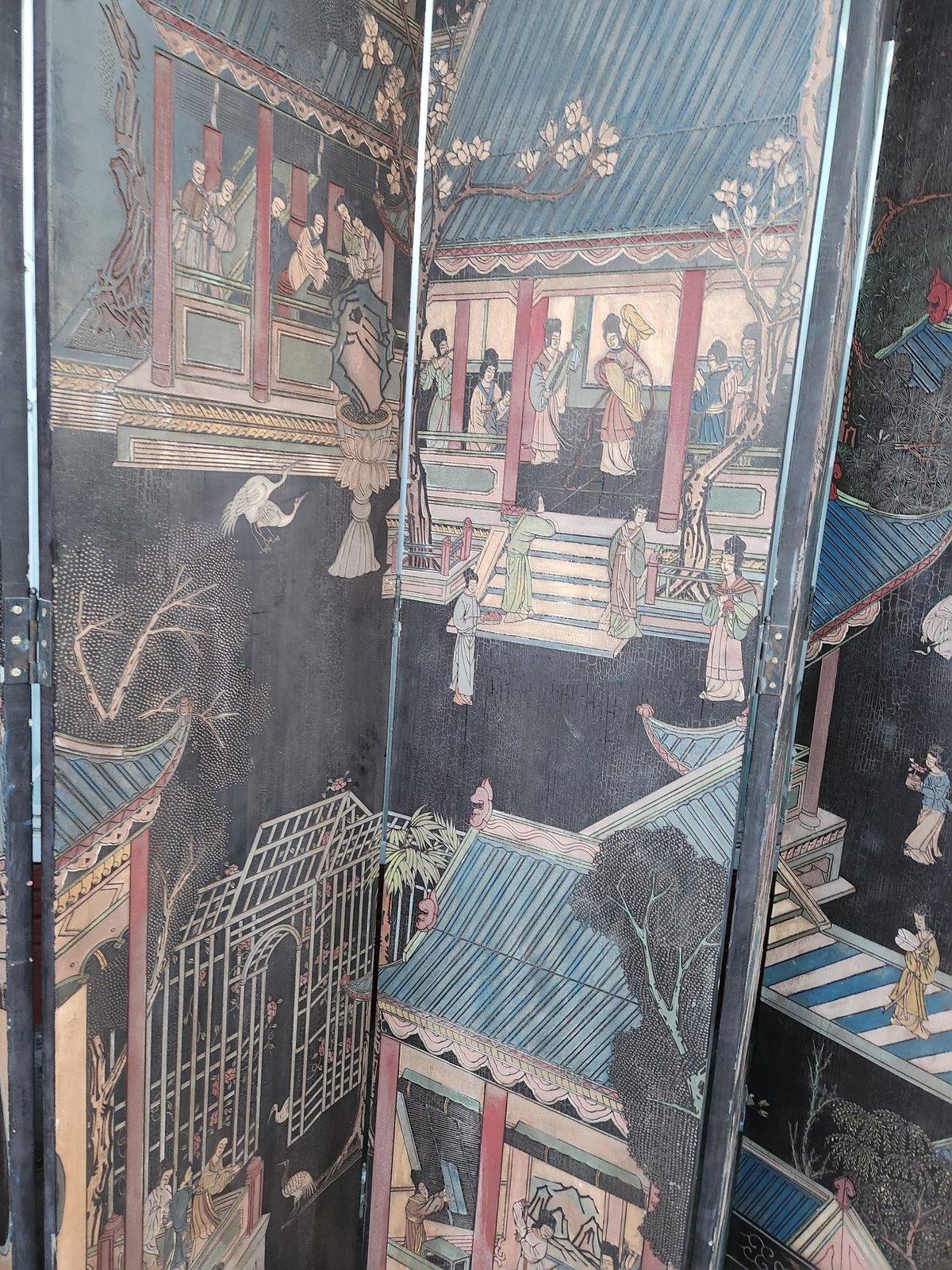 Antique wooden panel with intricate Asian artwork depicting buildings and figures in traditional style on dark lacquered surface