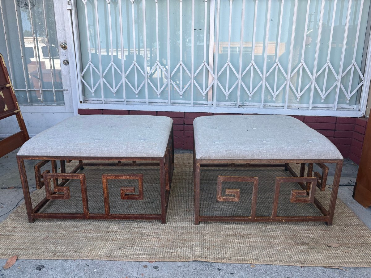 Two wooden benches with cream cushions and geometric patterns, displayed against a metal gate backdrop