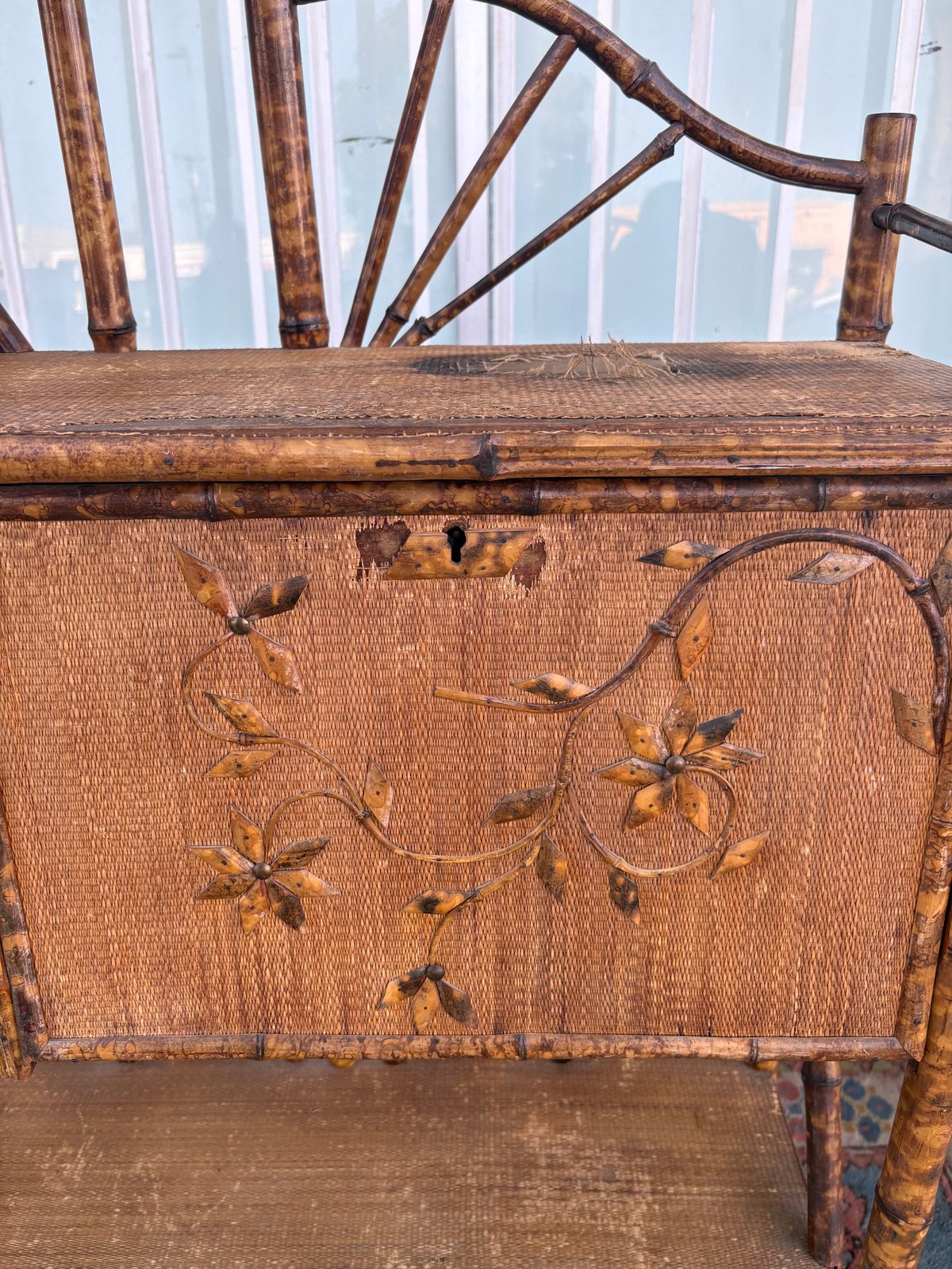 Antique wooden chair with ornate branch backrest and embroidered leaf design on tan upholstered seat