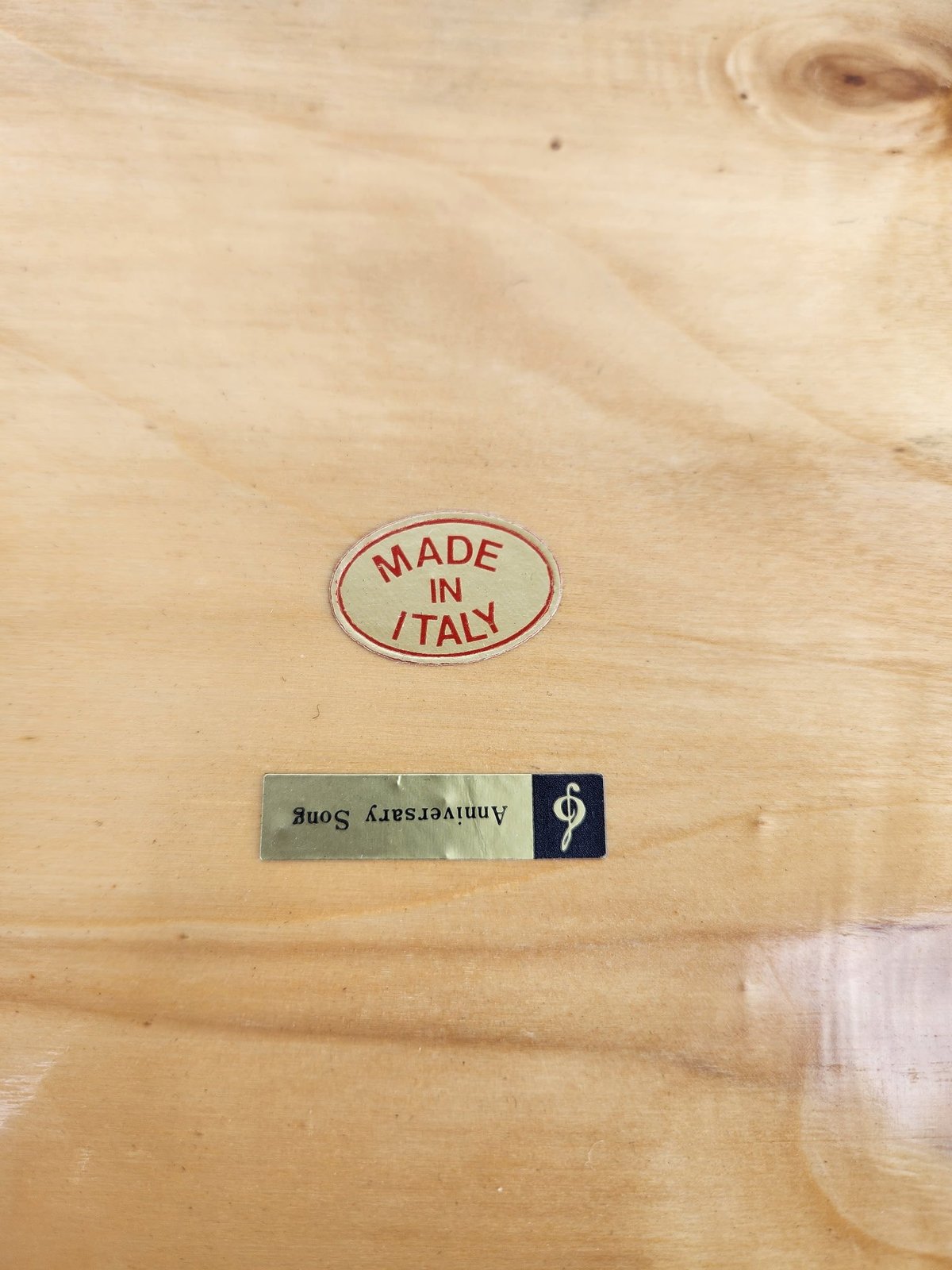Close-up of wooden surface with Made in Italy stamp and manufacturer label